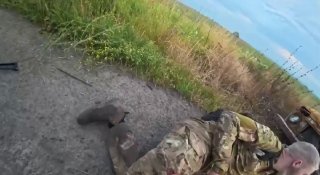 Медик помогает раненому бойцу на передовой